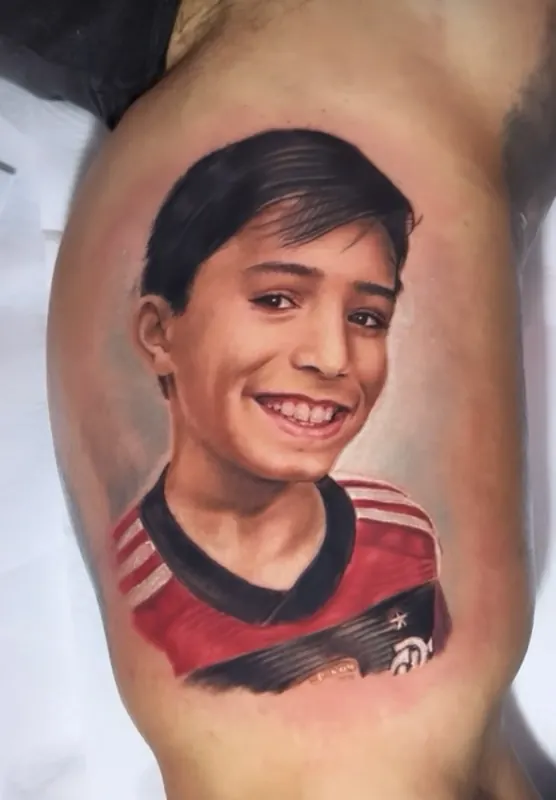 Retrato em realismo tatuado no braço