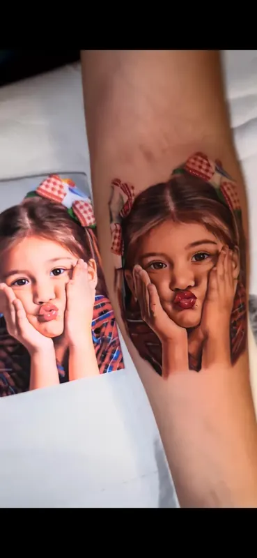 Tatuagem em realismo ao lado da foto de referência impressa